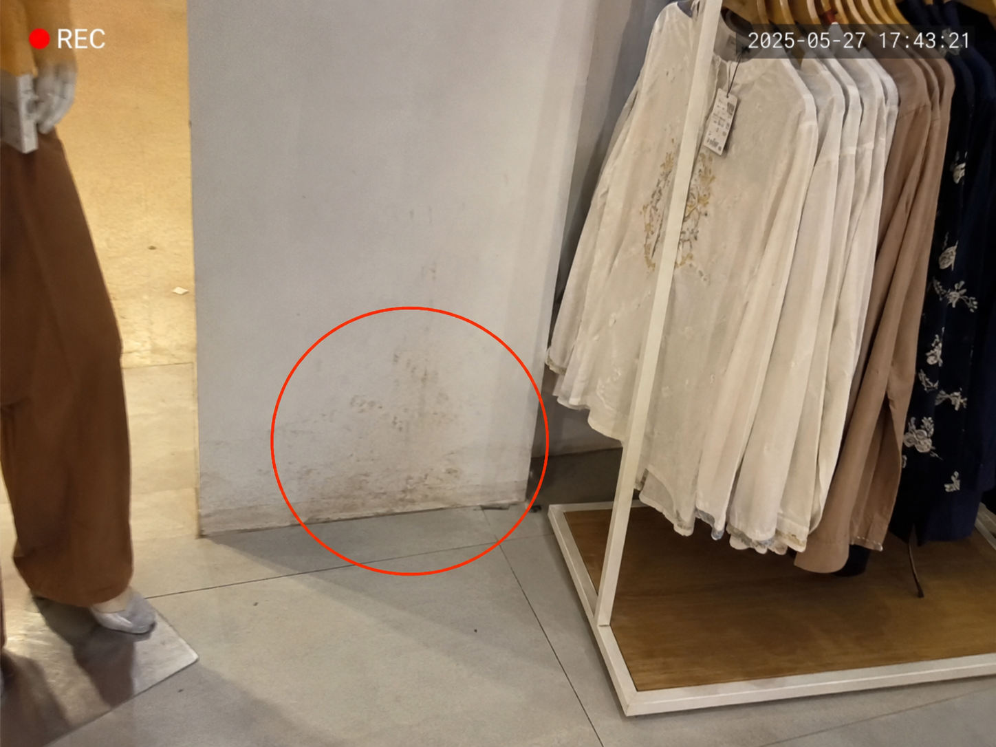 Anonymised retail store image showing stains on a wall near merchandise